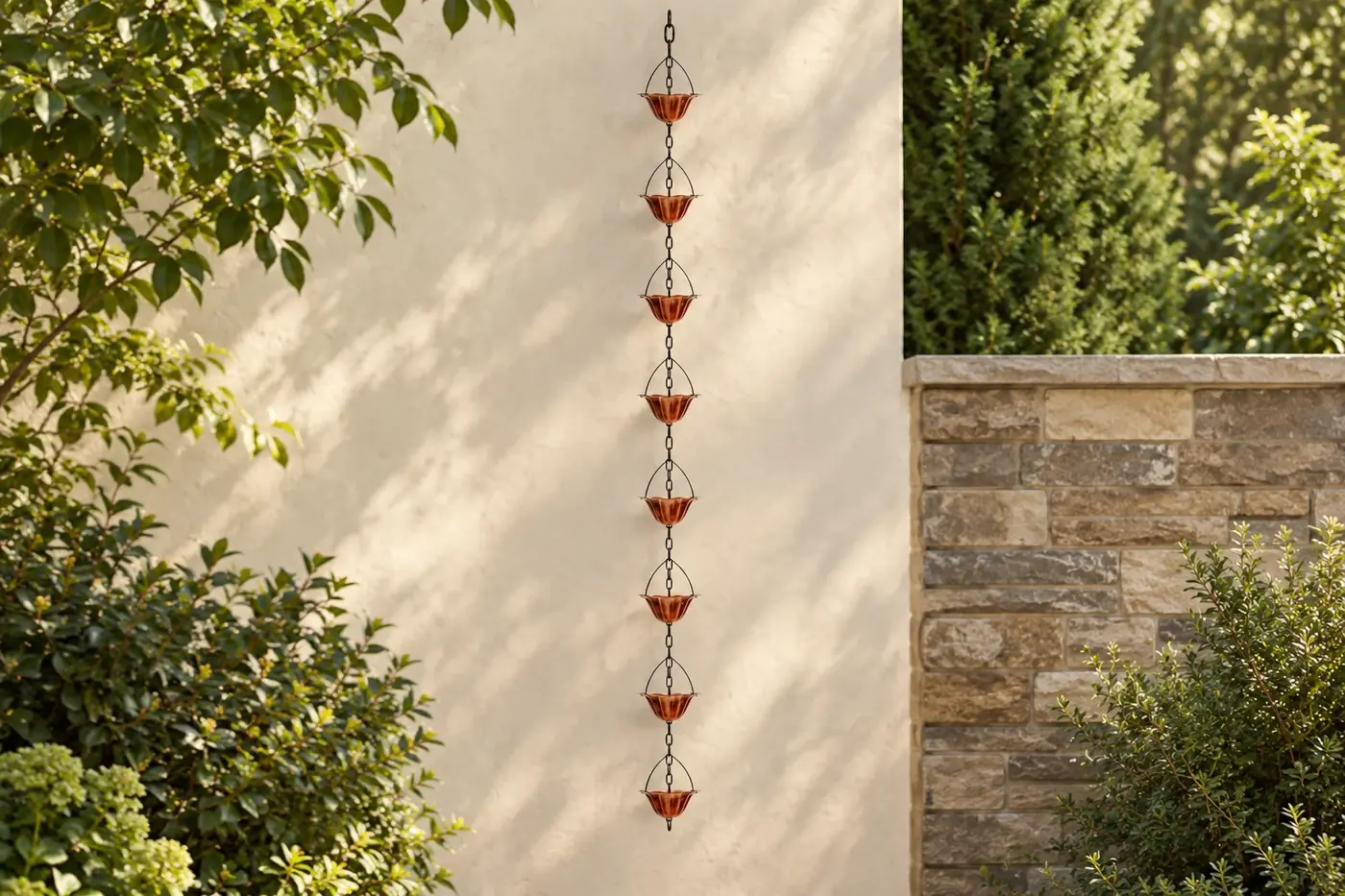 Eight copper-tone cups hanging in a leafy garden setting