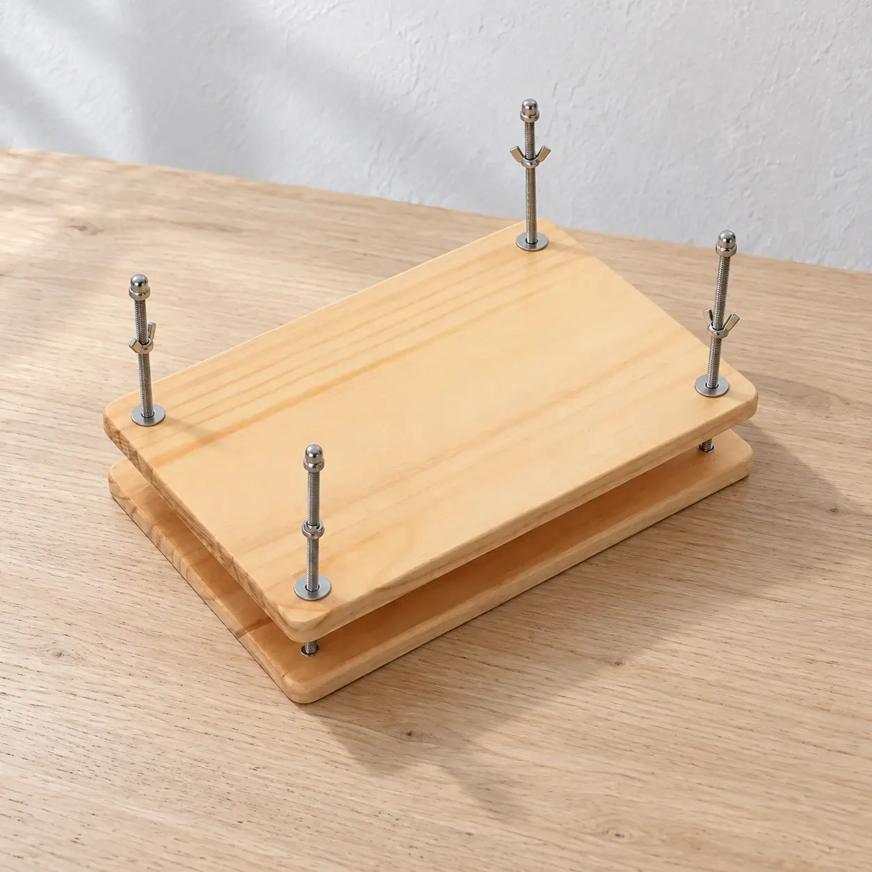 Pine book press with four threaded corner posts