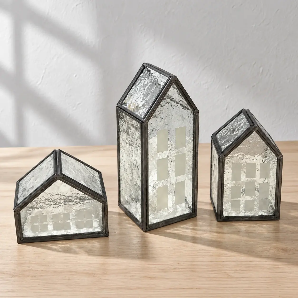 Three textured-glass house lanterns on a wood table