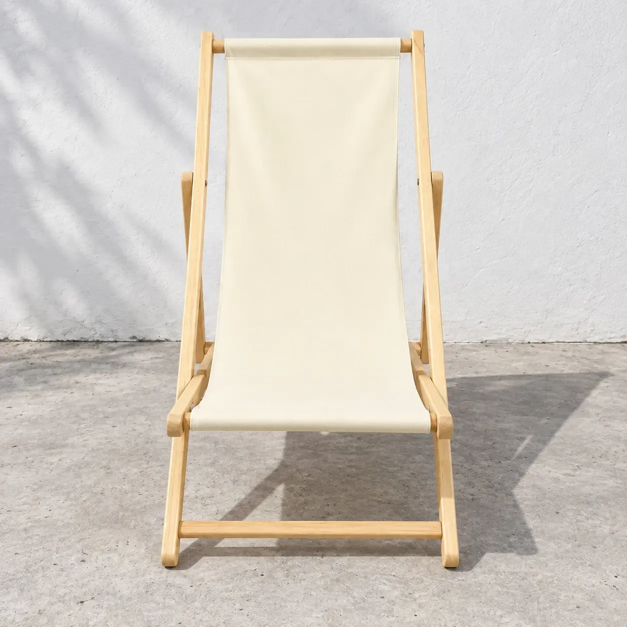 Cream canvas deck chair with pale wood folding frame