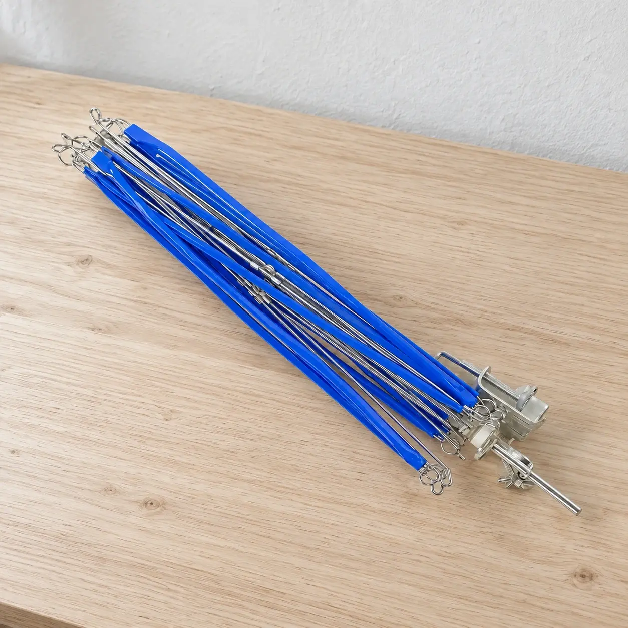 Folded blue and silver yarn swift on a wood worktable